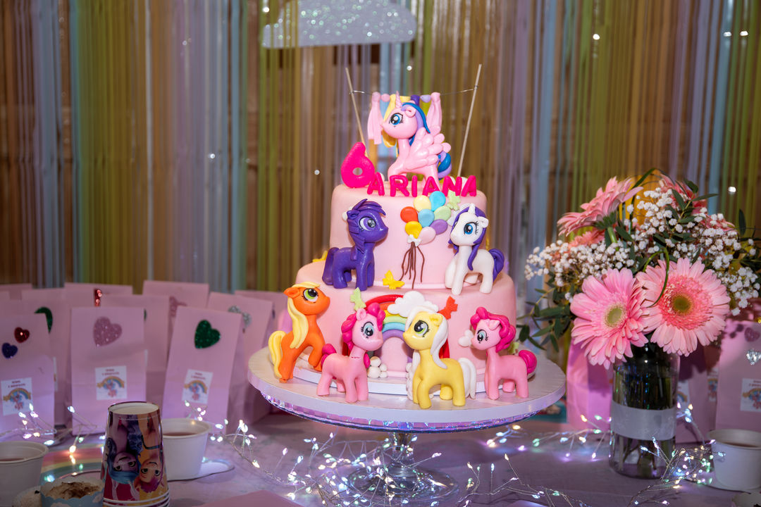 Unicorn-themed birthday cake on a decorated table.