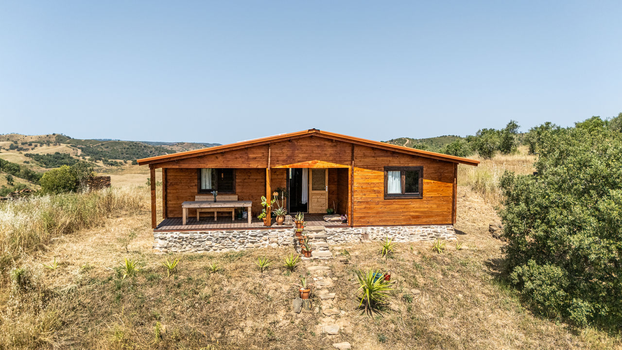 Off-grid wooden house near Sabóia, Alentejo, surrounded by rural countryside and open land.