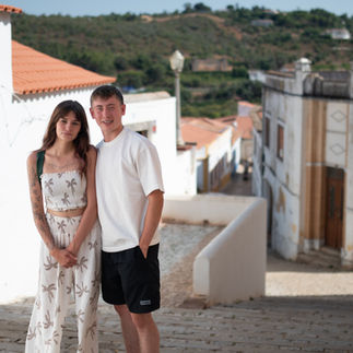 Young couple standing together on the cobbled streets of Silves, Portugal, during a portrait photoshoot by Oceanview Creations