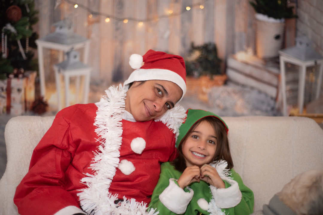 Adult and child hugging in holiday outfits.
