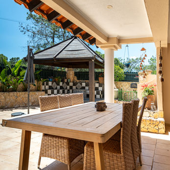 Covered terrace dining area at a Divine Home villa.