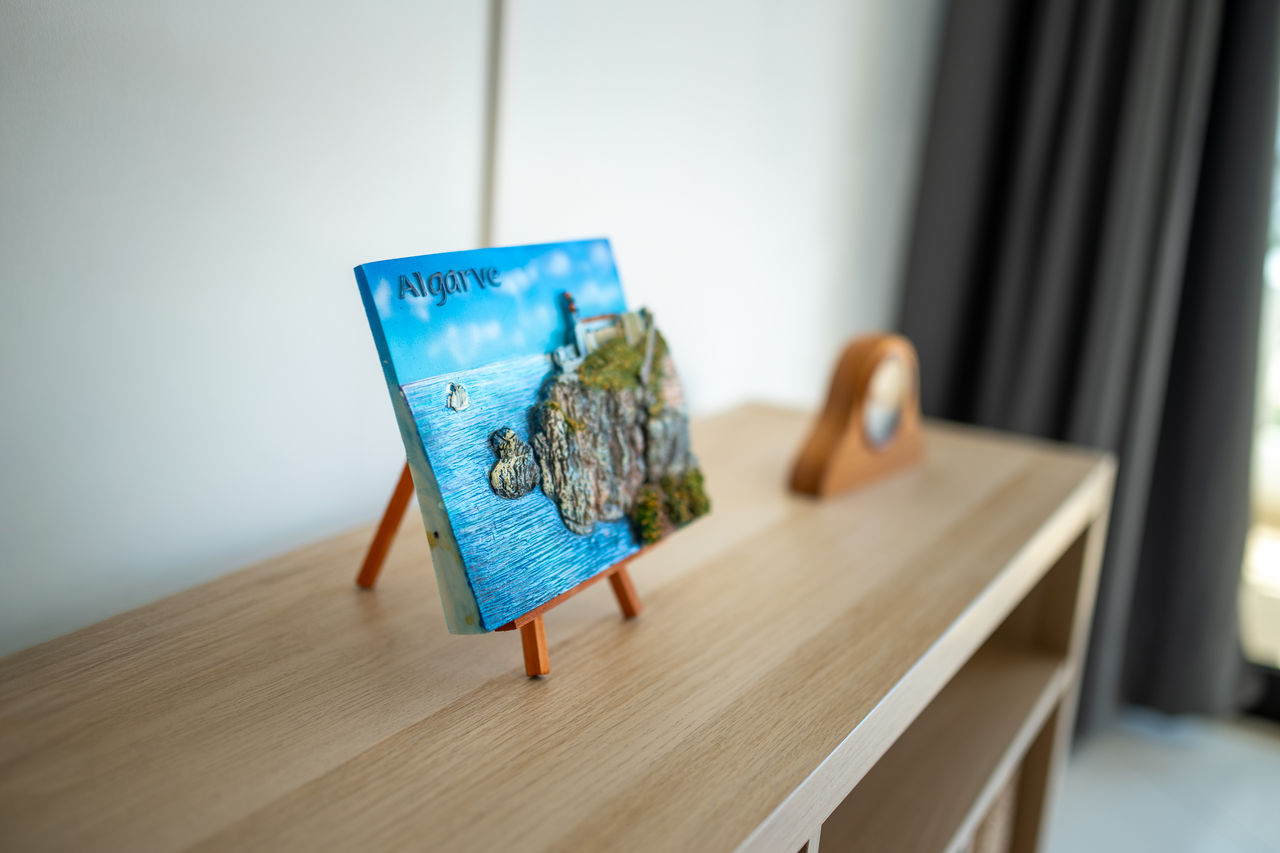 Close-up detail of Algarve decorative artwork on a wooden shelf, adding character and local style to the interior.