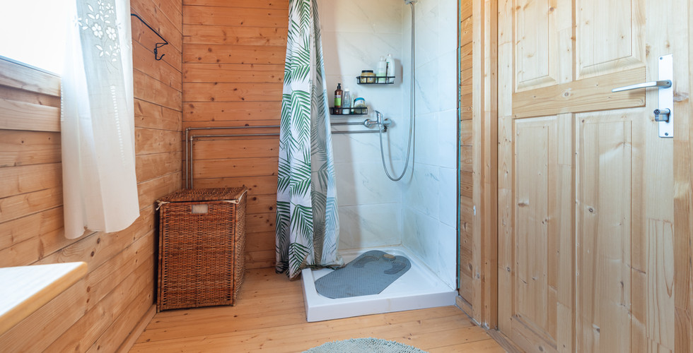 The bathroom image completes the practical view of the wooden house and its existing living faciliti