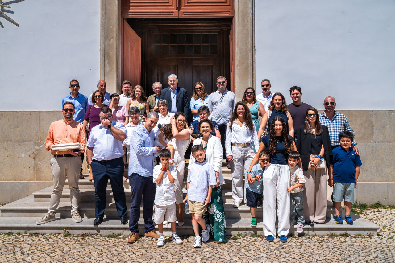 Large family group photographed outside a church after a baptism ceremony in Southern Portugal.