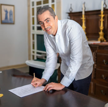 Father signing the baptism register after the ceremony.
