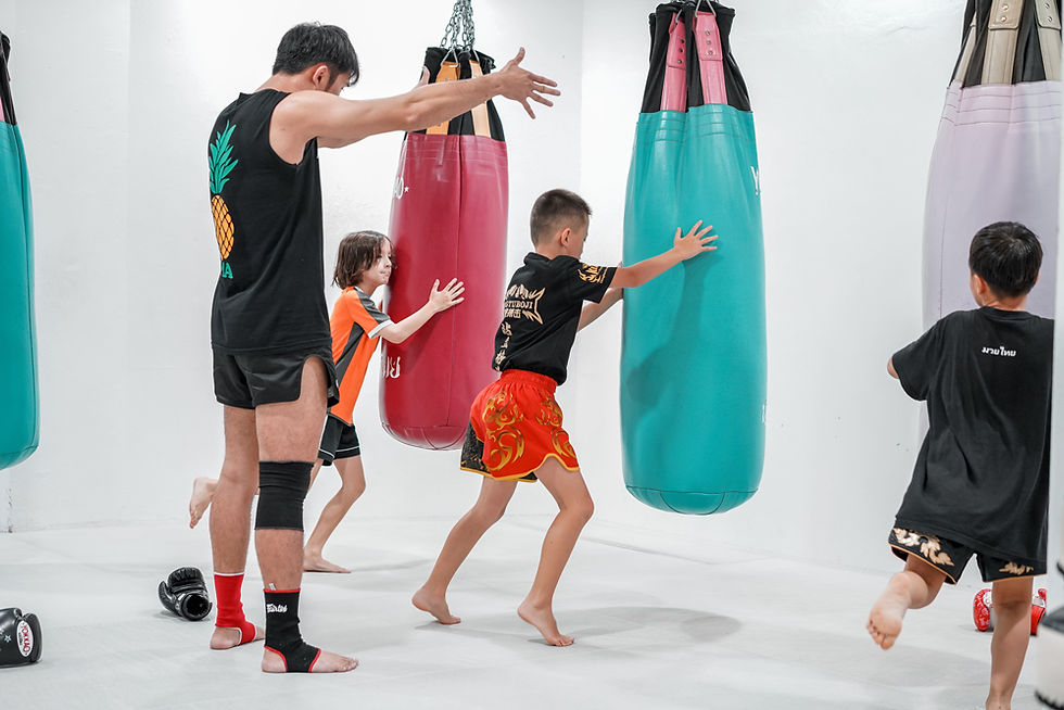 Group of children training together on punching bags in a Pineapple kids martial arts program.