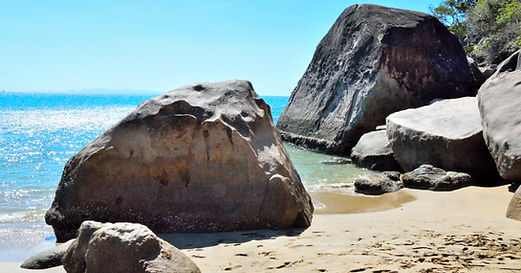 A  beach on Magnetic Island on a sunny day with large boulders. 