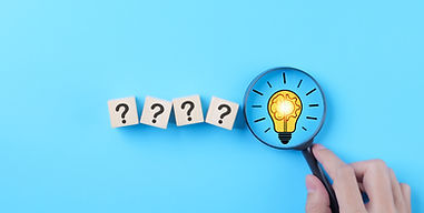 Idea discovery and inquiry concept. Hand holding a magnifying glass over question marks wi