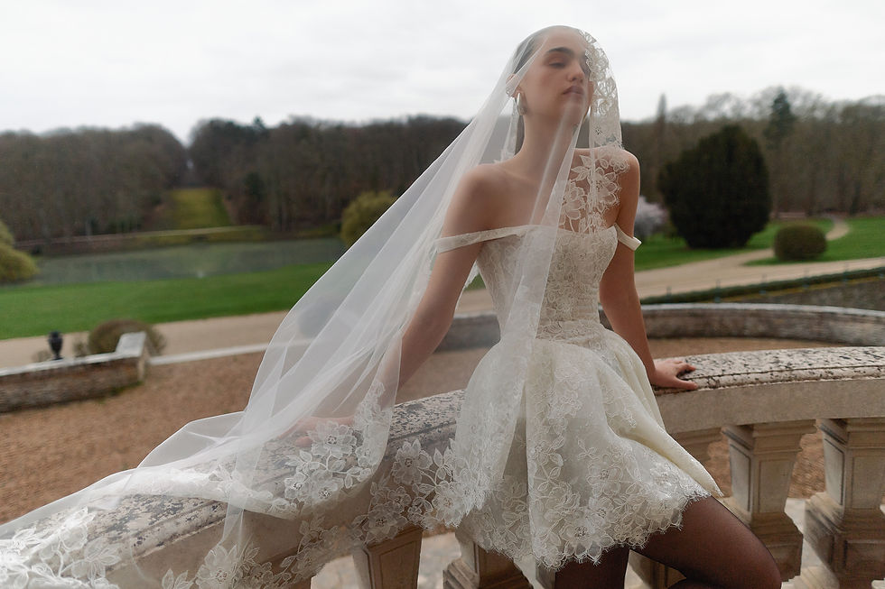 Sposa con velo in pizzo seduta sulla balaustra di una villa, abito Wona