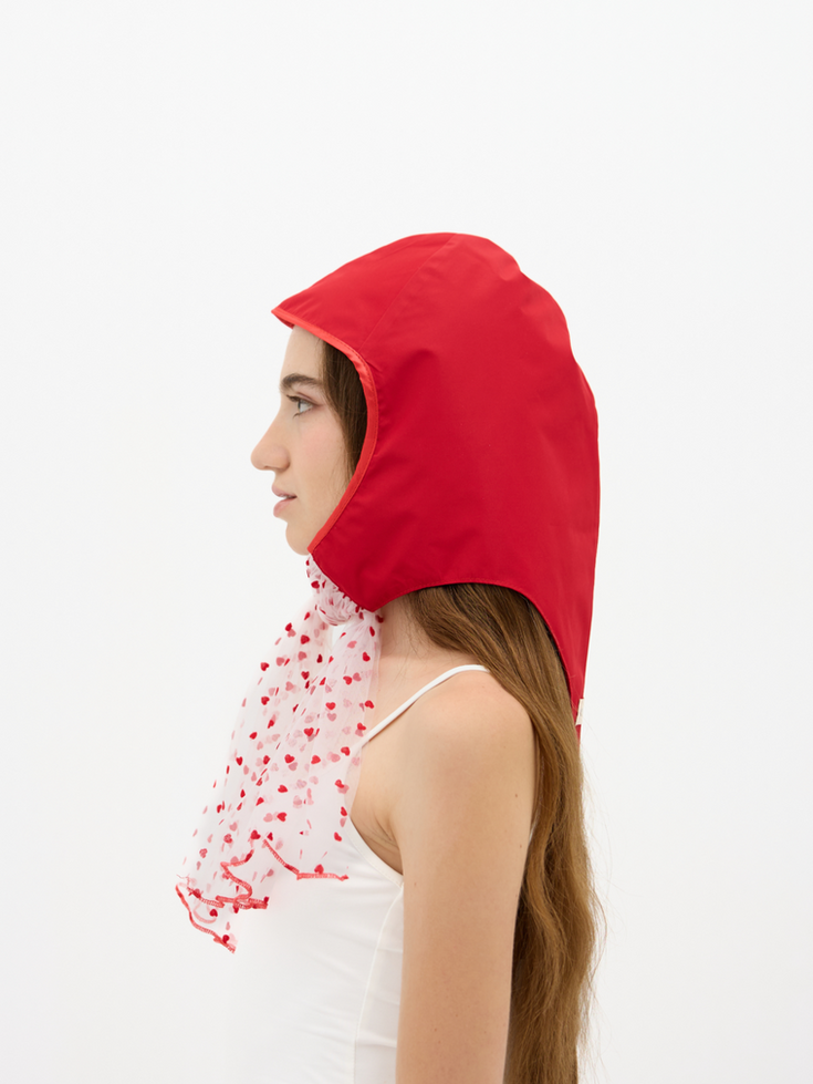 La Clochette Poppy Red with Soft Hearts, headpiece transparent tulle with hearts patterns worn by a woman, profile view