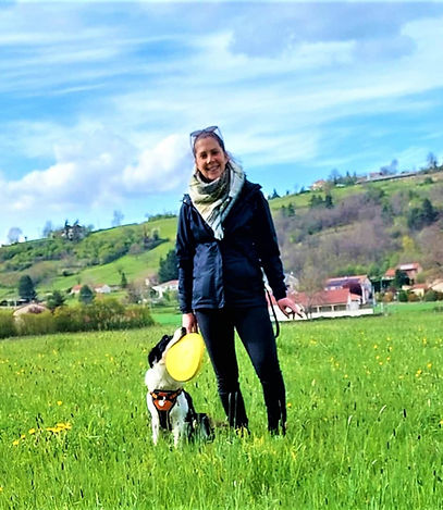 éducatrice canin souriante avec son chien qui la regarde