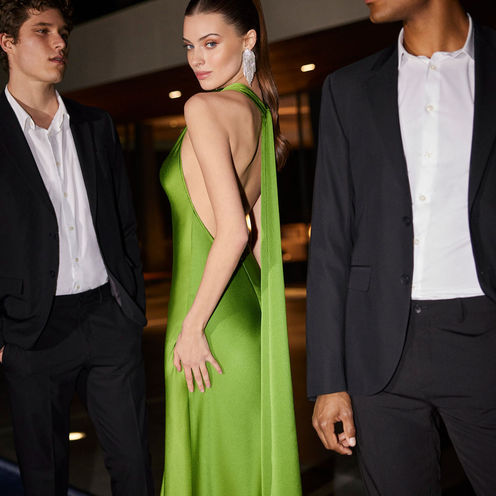 Donna in abito verde e due uomini in abito. Sposami Atelier.