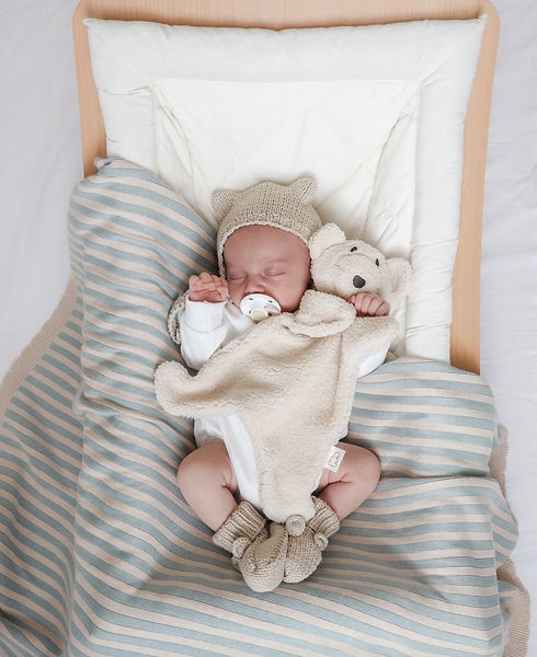 Sleeping baby wearing a knitted romper 