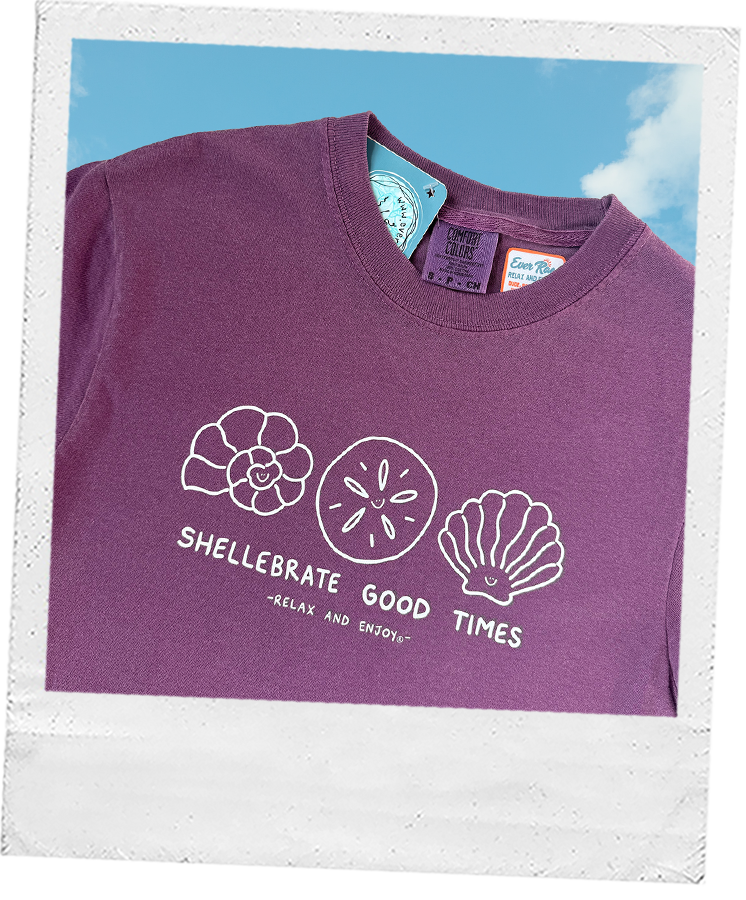 Thumbnail: Purple t-shirt with three seashell illustrations and the text “shelllebrate good times.”