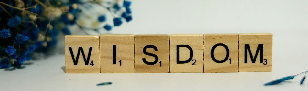 "Wisdom" spelled with scrabble pieces and bouquet of blue flowers