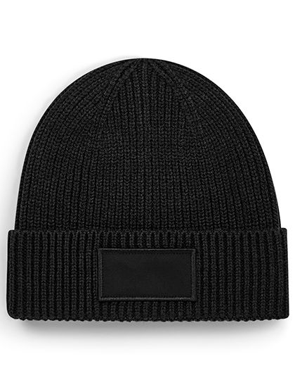 Schwarze gerippte Beanie-Mütze mit schlichtem schwarzem rechteckigem Aufnäher.