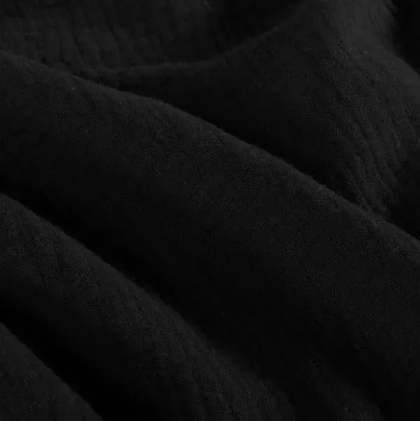 Schwarzer Stoff mit weichen Falten und subtiler, samtiger Textur.