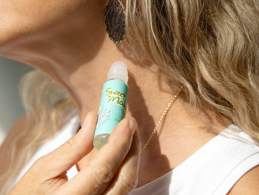 woman applying aromatherapy oil as perfume on neck