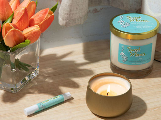Lotion Candles on a wooden table next to lip balm and peach tulips