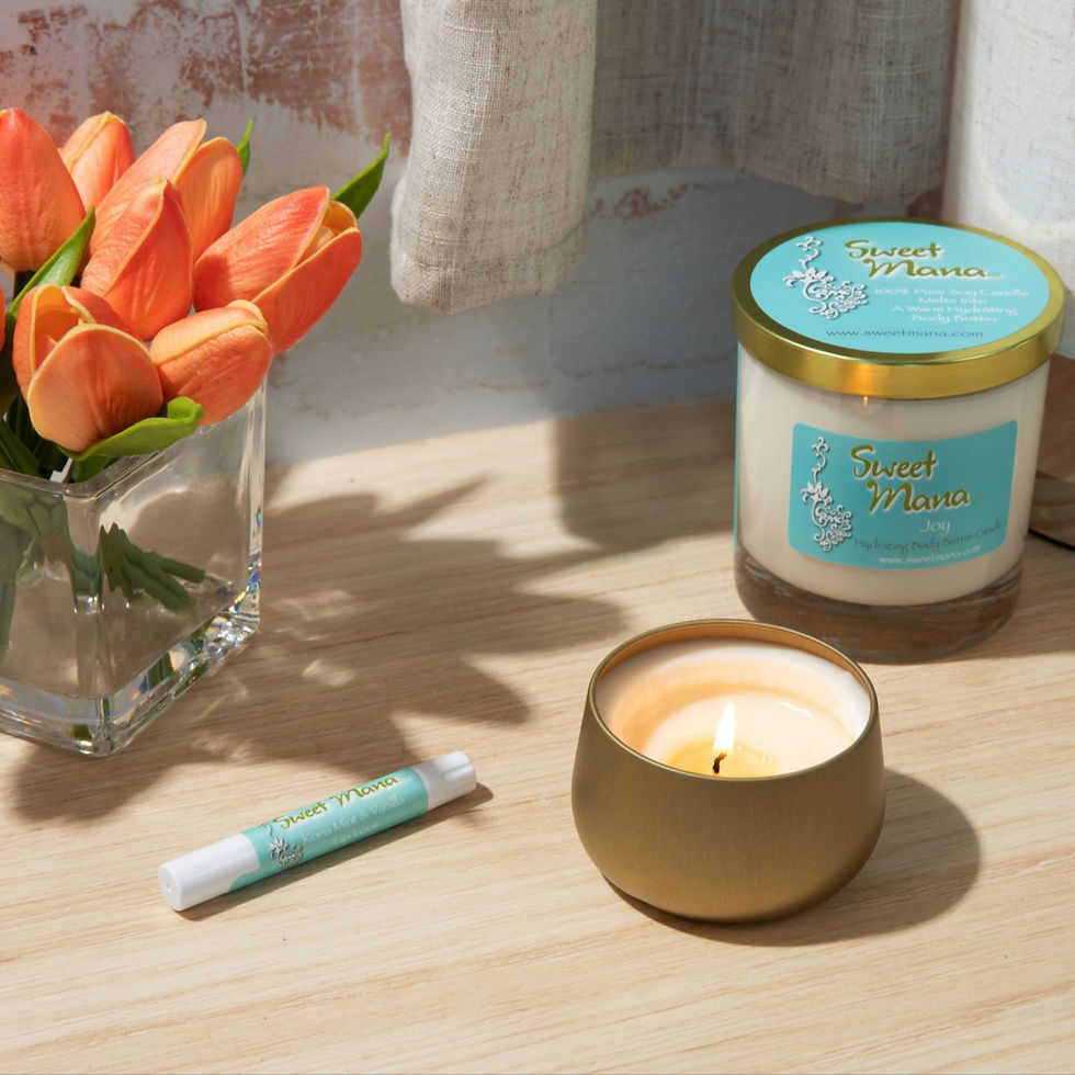 Sweet Mana lotion candles on desk next to lip balm and peach tulips