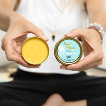 woman holding a Sweet Mana Be Well CBD Topical rub