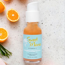 Sweet Mana's Vitamin C Brightening Serum next to orange slices