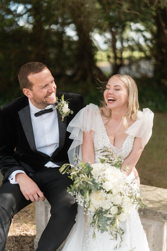 Bride holding bouquet and groom with buttonhole