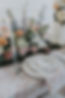 Table setting with a meadow of pastel florals and candles in the background