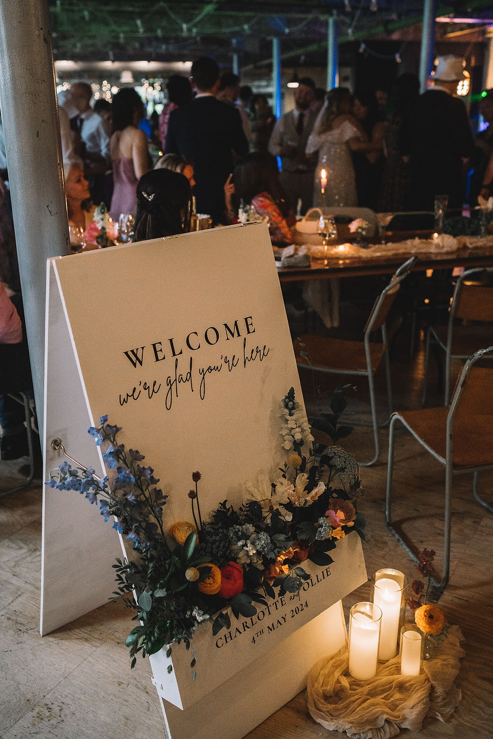 A board flower box sign with florals and candles