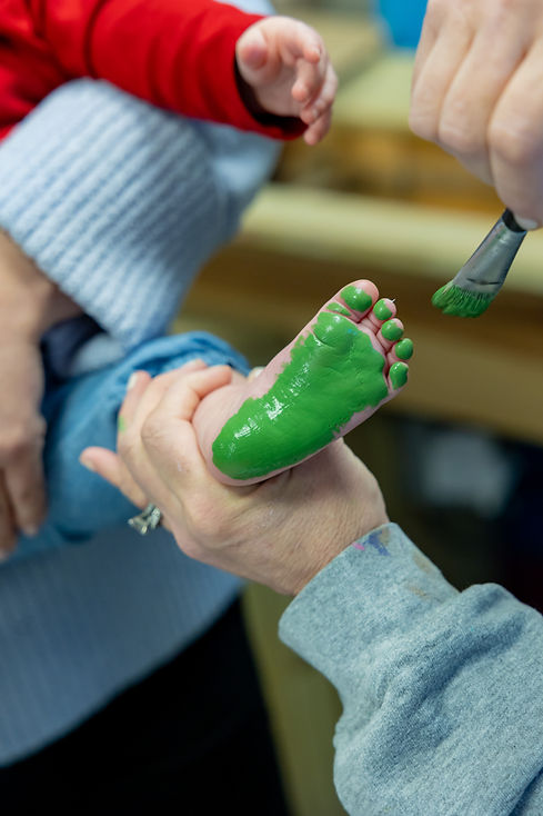 Baby's foot being painted with green paint
