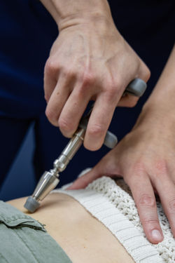 Patient receiving gentle chiropractic care for low back pain at Potens Wellness Clinic in Gladstone
