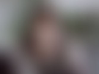 woman with cold/flu blowing her nose under plaid blanket