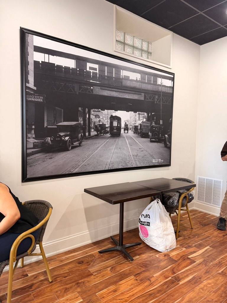 People sitting near a vintage cityscape photo.