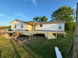Workers installing deck boards on a newly constructed deck, creating a sturdy surface for outdoor gatherings.