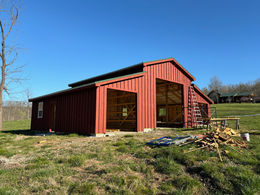 Construction of a Mountain Grove barn progressing from foundational base to a completed, fully enclosed structure.