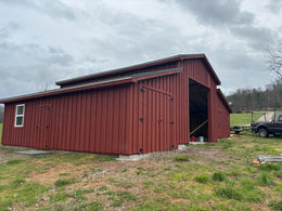 Construction of a Mountain Grove barn progressing from foundational base to a completed, fully enclosed structure.