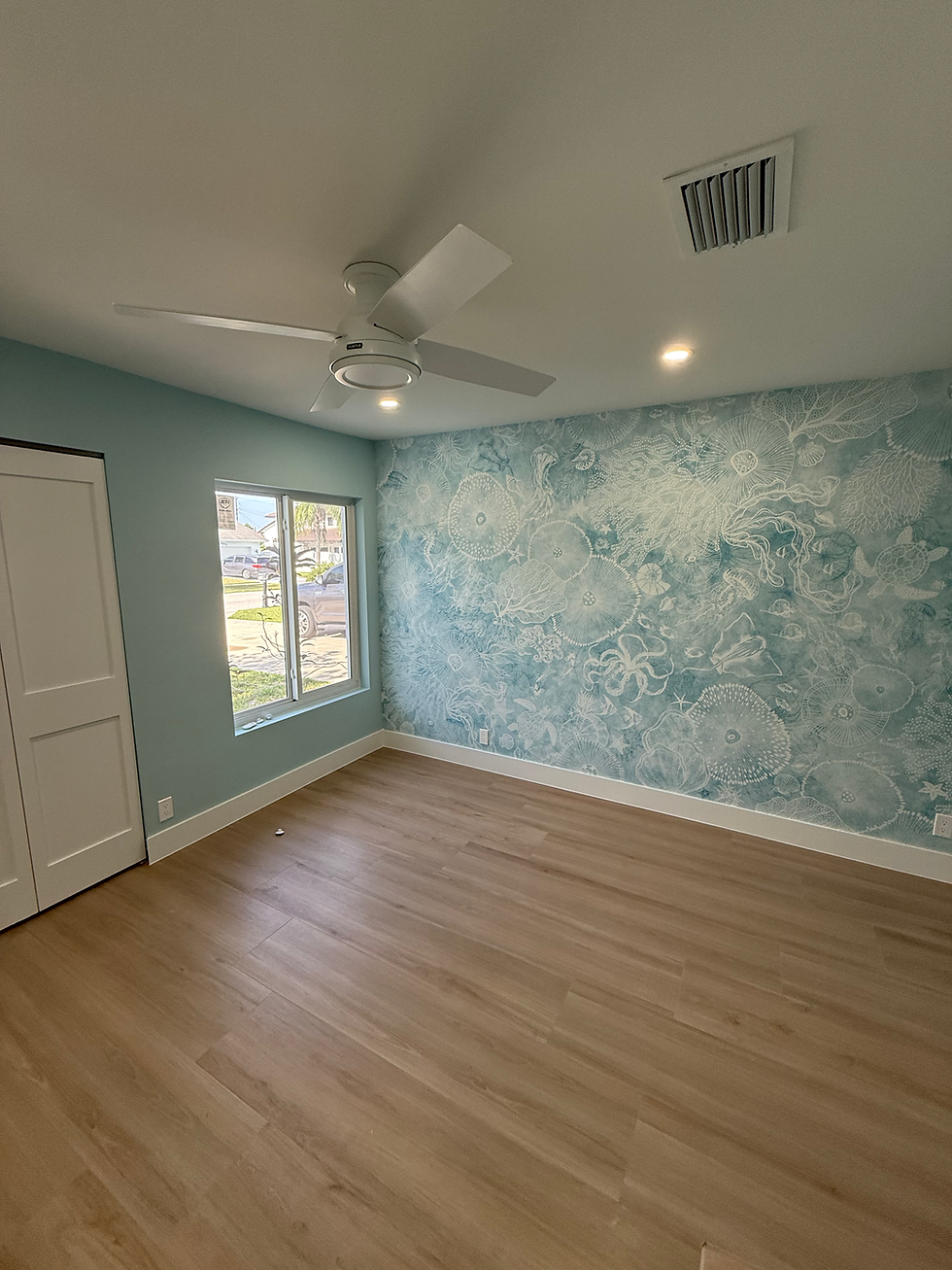 Bedroom remodel with blue floral accent wall and wood floor.