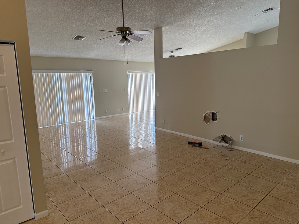 Spacious living area under remodel with tile floors.