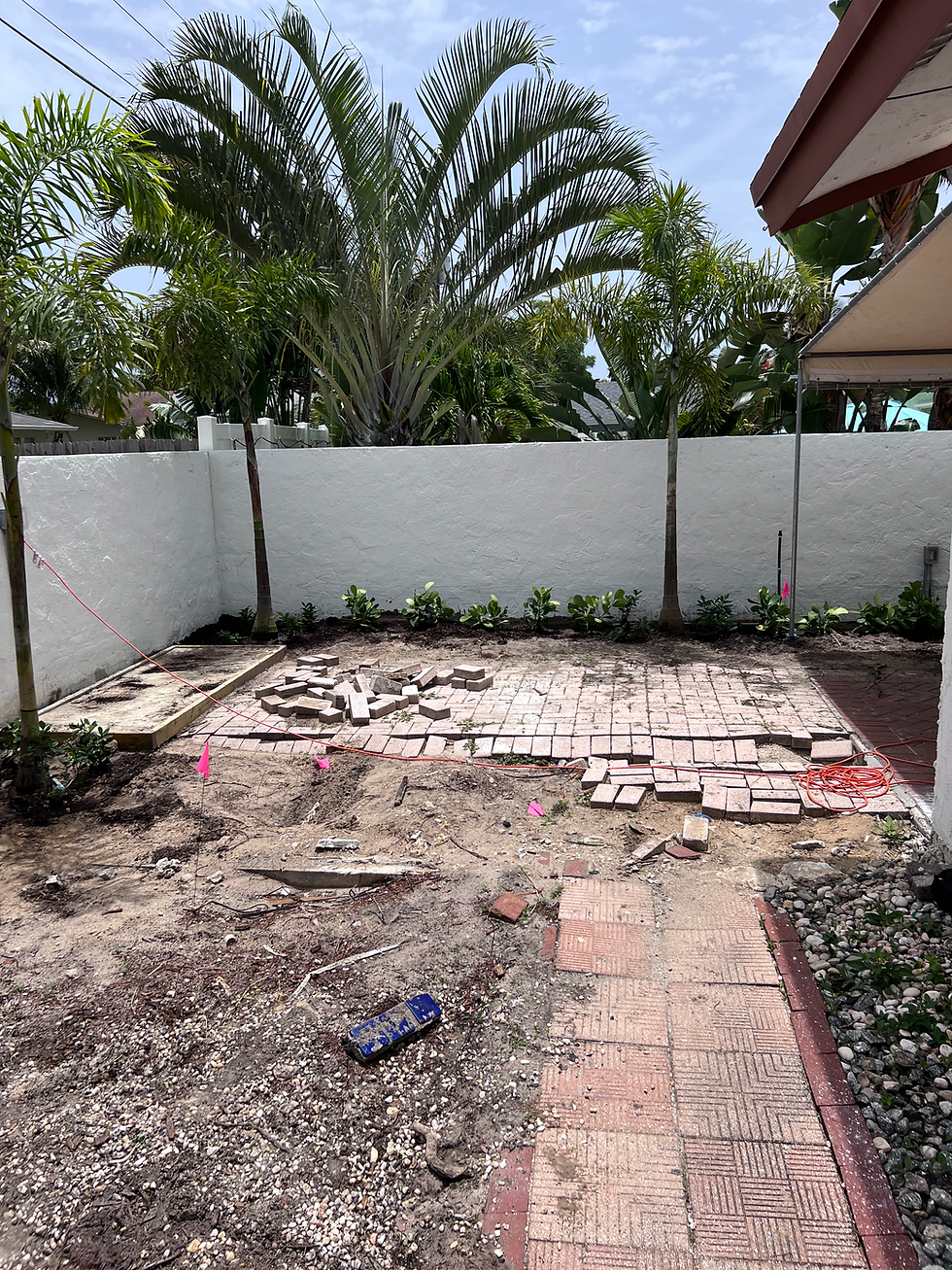 Patio remodel in progress with excavated dirt and pavers.