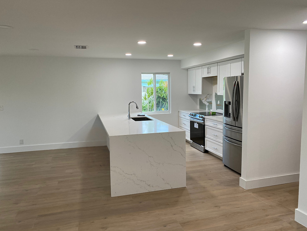 Modern kitchen remodel with white island, quartz countertop waterfall edge, and counters.
