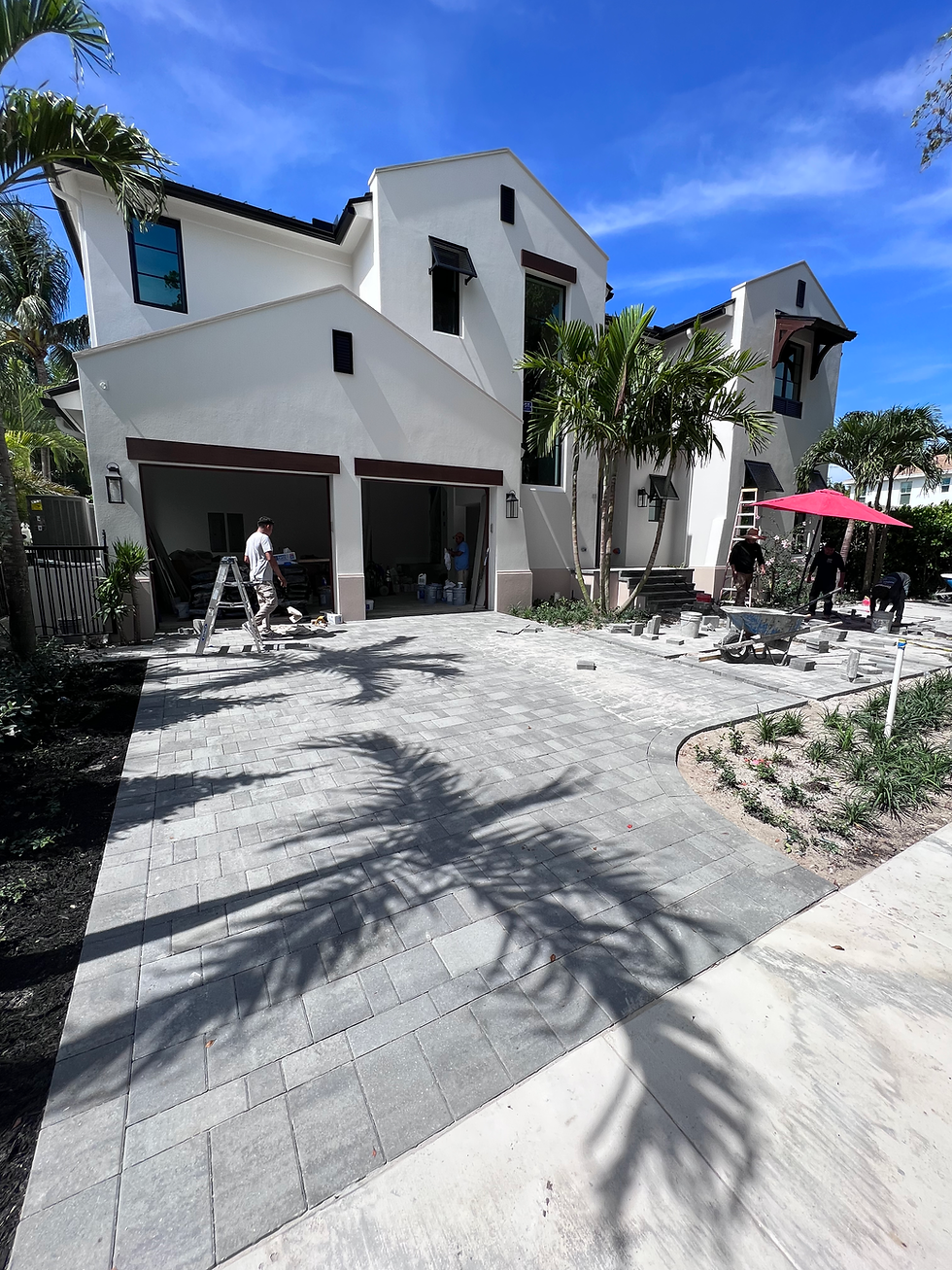 Modern home exterior remodel with new paver driveway.