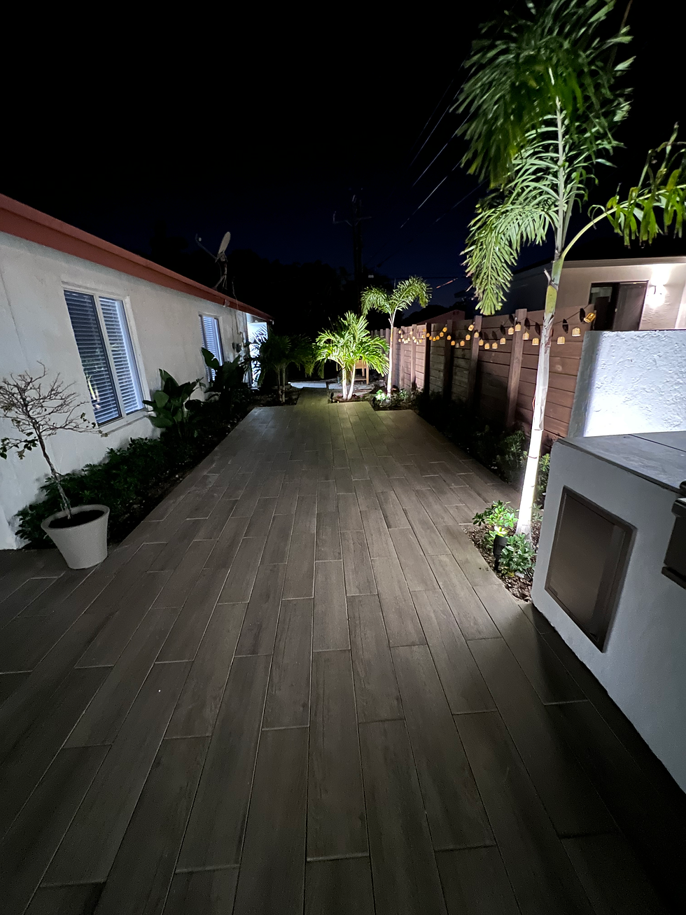 Illuminated low voltage lighting modern walkway remodel at night.
