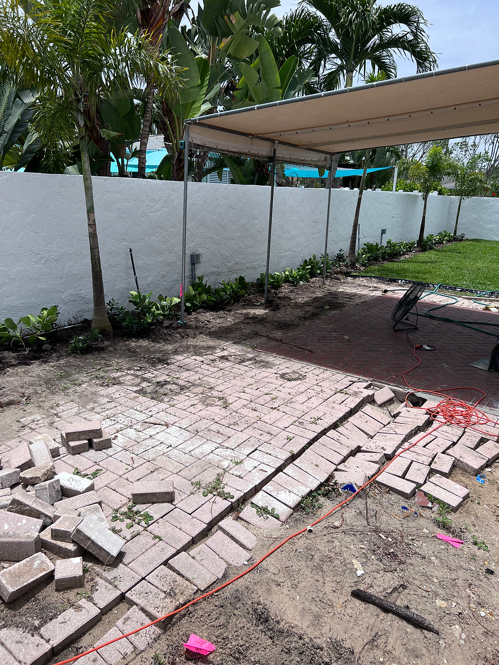 Backyard patio brick remodel in progress near white wall
