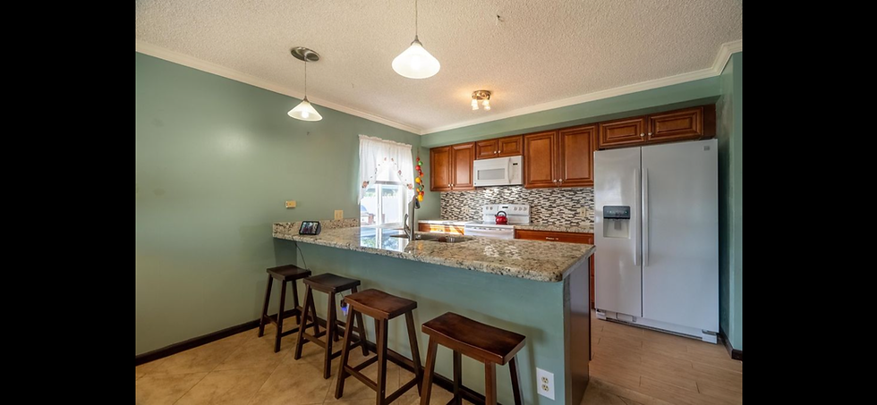 Outdated kitchen remodel with granite island and bar stools