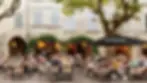 Bustling cafe culture and dining at the historic Place aux Herbes in Uzes, France.