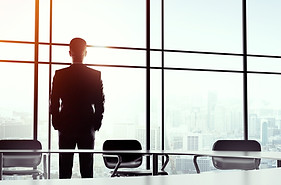 CEO Looking Out the window of a Skyscaper office building