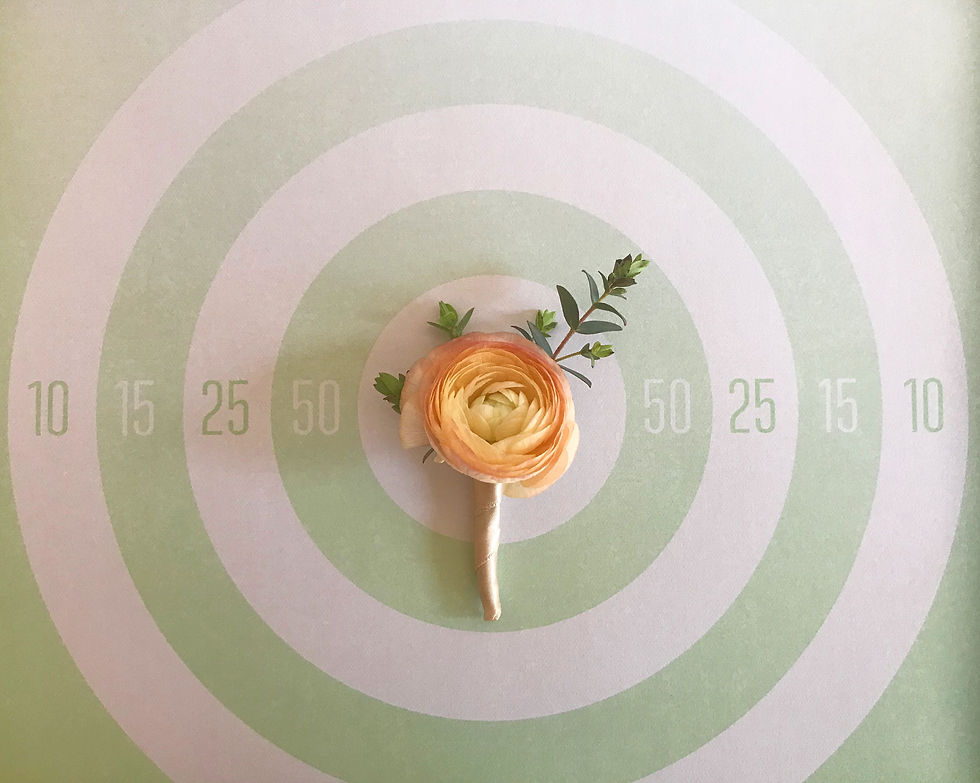 Peach ranunculus boutonniere wrapped in champagne ribbon with gunning eucalyptus