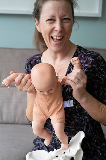Birth coach smiling with a baby