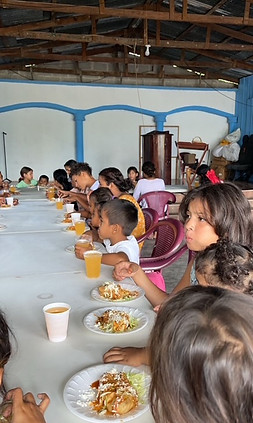 “Children sharing a meal at a community outreach program supported by Esteban’s art.”
