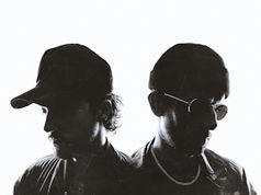 Two men in profile against a white background, wearing dark caps. One has sunglasses and a chain. The mood is mysterious and edgy.